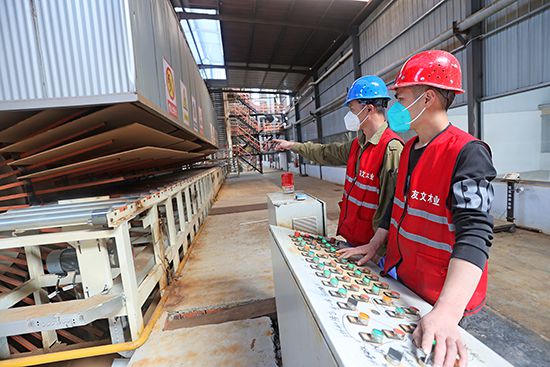 丁集镇淮安友文人造板制造的员工正在升级改造的全自动生产线上忙碌
